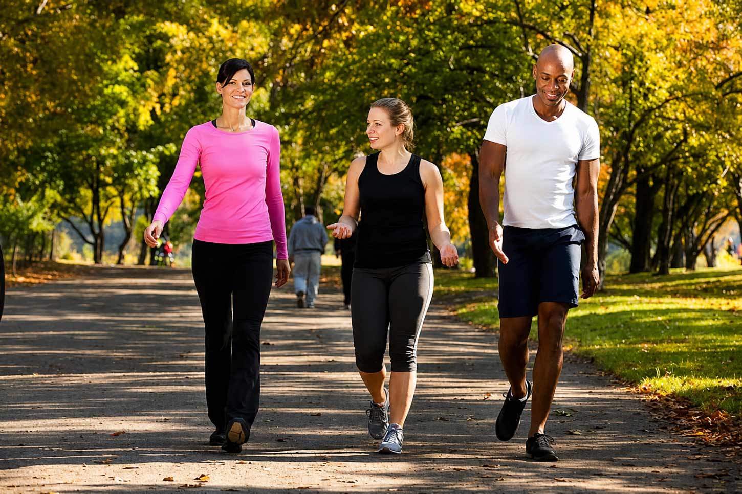 Exercise image Three adults walking together in a park for exercise and mental well-being